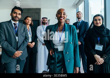 Verschiedene Geschäftsleute, die verschiedene Kulturen und Geschlechter vertreten, stehen in einem modernen Büro und posieren für ein Gruppenporträt bei einem globalen unternehmen Stockfoto