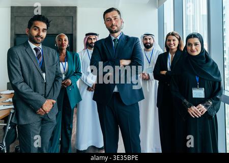 Verschiedene internationale Geschäftsleute stehen selbstbewusst zusammen und repräsentieren globale Zusammenarbeit und erfolgreiche Unternehmenspartnerschaft Stockfoto