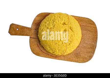 Heiße dampfende Polenta mit rotem Garn auf einem alten Holzbrett, ein traditioneller Maisbrei, der in Rumänien und Moldau ein Grundnahrungsmittel ist und oft auch verwendet wird Stockfoto