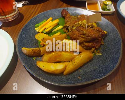 Ayam Betutu ist ein traditionelles balinesisches Essen, das aus einem ganzen Huhn mit Gewürzen hergestellt und dann in einem Schalen-Feuer geröstet wird. Stockfoto
