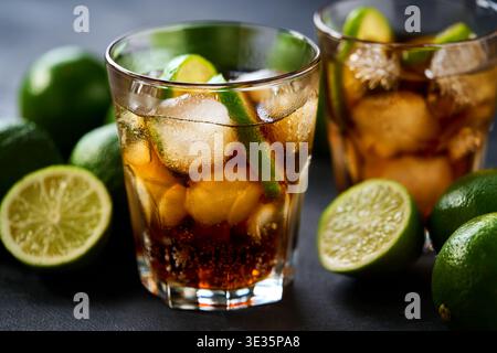 Gläser leckerer Cuba Libre Cocktail auf dunklem Holzhintergrund, selektiver Fokus. Cuba Libre oder Long Island Ice Tea Cocktail. Stockfoto