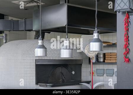 Traditioneller Pizzaofen in professioneller Restaurantküche. Lebensmittelzubereitungskonzept mit kommerzieller Kochausrüstung und italienischer Küche. Stockfoto