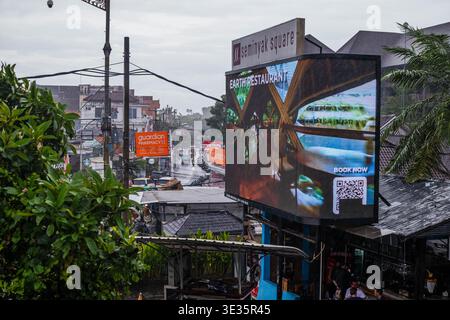 Große LED-Reklametafel mit Blick auf eine belebte regnerische Straße Stockfoto