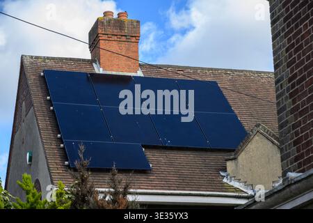Wohnhausdach mit Solarpaneelen, die saubere erneuerbare Energie, nachhaltiges Wohnen und umweltfreundliches Wohnkonzept erzeugen. Stockfoto