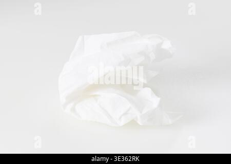 Diese Studio-Nahaufnahme mit hohem Winkel verfügt über ein gebrauchtes oder entsorgtes weißes Gesichtstuch. Das Gewebe ist kompliziert zerknittert, es bildet verschiedene Falten, Ridg Stockfoto