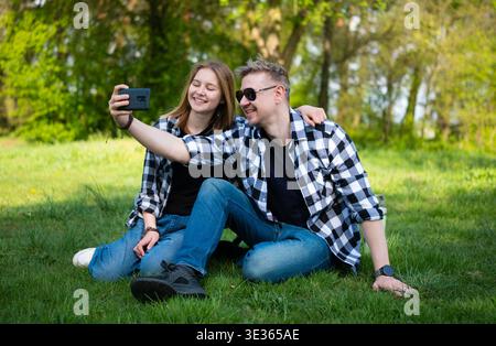 Glücklicher Vater Und Tochter, Die Selfie Mit Smartphone Auf Gras Nehmen Stockfoto