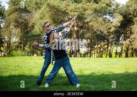 Glücklicher Vater und Tochter in Einer Familie Schau draußen, haben Spaß und stehen in Einer Sternenposition Stockfoto