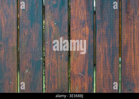 Nahaufnahme von dunkelbraunen Holzbrettern mit glänzend lackierter Oberfläche und sichtbarer Körnung. Stockfoto