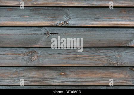 Nahaufnahme von grauen horizontalen Holzbrettern mit sichtbarer Körnung und Knoten. Stockfoto