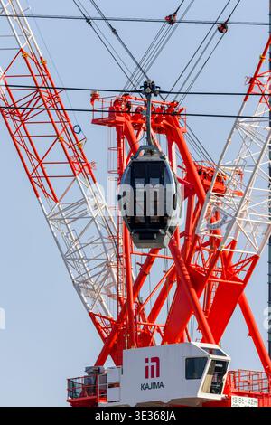 Yokohama Air Cabin Seilbahn, die vor einem riesigen roten Kajima-Baukran vorbeifährt Stockfoto