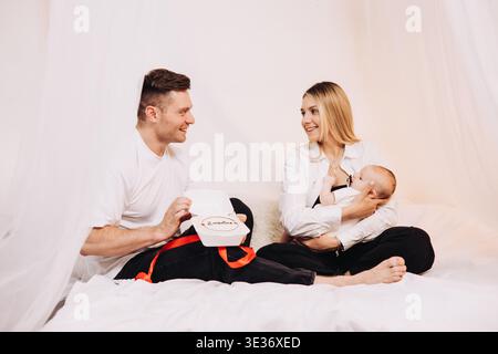 Neue Eltern interagieren freudig mit ihrem liebenswerten Baby in einer gemütlichen und einladenden Umgebung, die Liebe und Wärme ausstrahlt, die jeder Anwesende wirklich bewundert Stockfoto