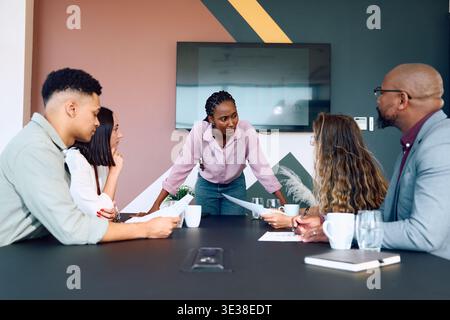 Selbstbewusste junge schwarze Geschäftsfrau, die tagsüber die Teamdiskussion im Büro leitet Stockfoto