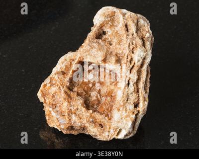 Makroaufnahmen von natürlichen Mineralien - Wulfenitkristalle auf rohen Felsen auf schwarzem Granit aus dem Ural Mountains Stockfoto
