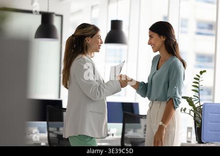 Junge Frauen Geschäftspartner, die im Büro Handschütteln, um produktive Teamarbeit zu feiern Stockfoto