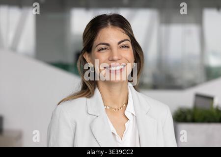 Kopffoto-Porträt lächelnde erfolgreiche Führerin, die im Büro nach vorne blickt Stockfoto