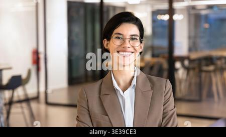 Kopffoto-Porträt einer lächelnden kaukasischen Geschäftsfrau, die im Büro steht Stockfoto