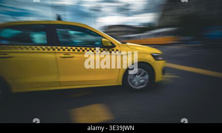 Rushing Yellow Taxi Car fährt schnell an der City Road mit Einem Bewegungsunschärfeeffekt Stockfoto