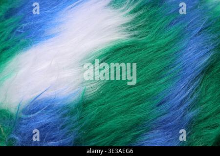 Nahaufnahme von bunten synthetischen Fasern mit weicher, flauschiger Textur in Grün-, Blau- und Weißtönen Hintergrund Stockfoto