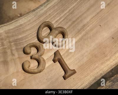 Rustikales Holz Zahlen acht, drei und eins auf natürlicher Holzmaserung. Nahansicht mit handgefertigtem Schriftzug mit warmer, nostalgischer Textur Stockfoto