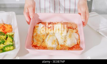 Frisch gebackener Knoblauchfisch, serviert mit geröstetem Gemüse. Stockfoto