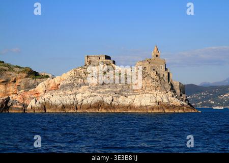 Die antike Kirche San Pietro mit markanter gestreifter Steinarchitektur steht auf einer zerklüfteten Klippe in Portovenere, Italien Stockfoto