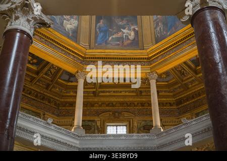 Battistero di San Giovanni in Laterano. Rom, Italien. Blick auf die kunstvolle goldene Kuppelkassette, korinthische Säulen und religiöse Fresken im Inneren des Ancien Stockfoto