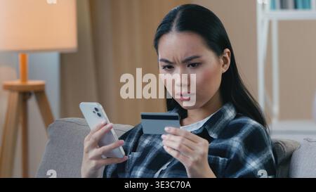 Wütend verwirrt asiatische japanische Frau versucht zu zahlen Handy e-Bank App Kreditkartenproblem gescheitert Online-Transaktion koreanische weibliche Frau frustriert Stockfoto
