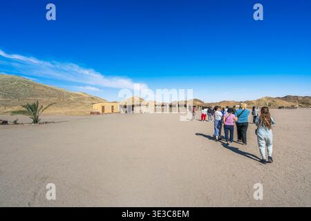 HURGHADA, ÄGYPTEN - 19. JANUAR 2025: Eine Gruppe von Touristen spaziert durch ein traditionelles Beduinendorf in der Wüstenlandschaft in der Nähe von Hurghada, Ägypten. Stockfoto