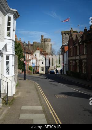Ein Blick auf das Schloss Arundel von der Maltravers Street mit Wohnhäusern und Straße im Vordergrund. An einem sonnigen blauen Himmel mit Union Jack fliegen. Stockfoto