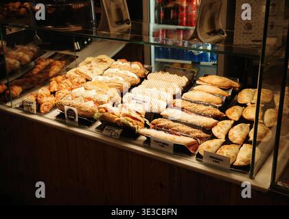 Verschiedene spanische Sandwiches, Empanadas und Bocadillos in einem Café in Barcelona in einer Glastheke mit katalanischen Preisen. Stockfoto