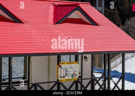 Zeichentrick-Sicherheitsschild, das vor Dachlawinen in einer Winterhütte in Nagano, Japan, warnt. Stockfoto