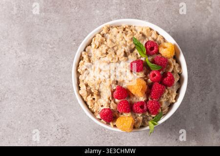 Köstlicher Haferbrei mit Himbeeren und Honig. Gesundes Frühstückskonzept. Stockfoto