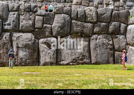Cusco, Peru - 22. März 2025: Touristen, die sich die beeindruckenden megalithischen Steinmauern von Sacsayhuaman in Cusco, Peru, ansehen Stockfoto