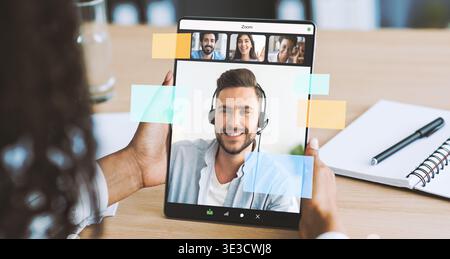 Nahaufnahme einer Frau, die während eines virtuellen Meetings mit Kollegen im Home Office mit einem Tablet arbeitet Stockfoto