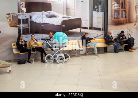 Die Leute entspannen auf Bänken in einem geräumigen Möbelgeschäft. Brünn 21. März 2026 Stockfoto