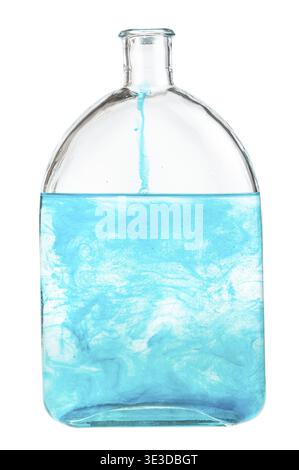Blauer Farbstoff löst sich in Wasser in einer Flasche auf weißem Hintergrund auf Stockfoto