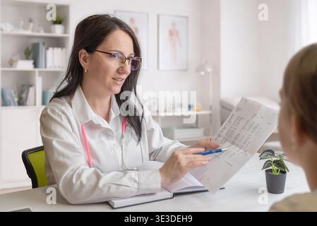 Arzt, der medizinische Ergebnisse dem Patienten in der Klinik präsentiert, stellt medizinische Beratung, Diagnose und professionellen medizinischen Service dar Stockfoto