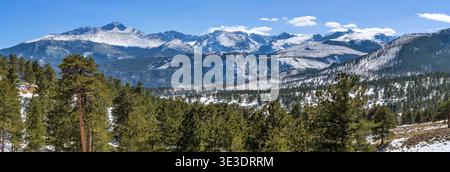Rocky Mountain National Park - Panorama der schneebedeckten nördlichen Front Range Berge, die an einem sonnigen Frühlingstag links vom majestätischen Longs Peak geführt werden. Stockfoto