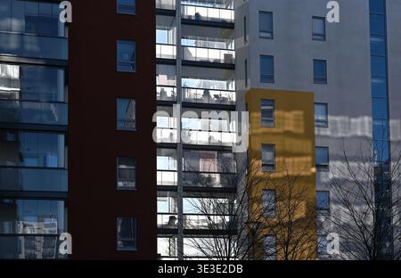 Die Fassade eines modernen Wohngebäudes mit farbenfrohen Paneelen, Glasbalkonen und geometrischer Architektur mit Reflexionen und Schatten-Crea Stockfoto