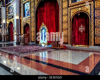 Ägypten, Scharm El Sheikh - 18. Januar 2020: Altar mit Ikonen in der koptischen Kirche El Sama Eyeen in Scharm El Sheikh. Große Halle mit goldenem Dekor an den Wänden Stockfoto