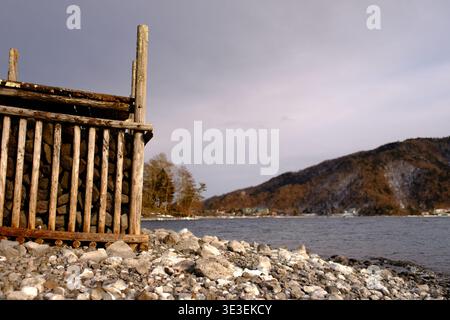 JAPAN - 7. FEBRUAR 2026: Die zerklüftete Küste des Lake Chuzenji mit einem traditionellen Holzsteg. Stockfoto