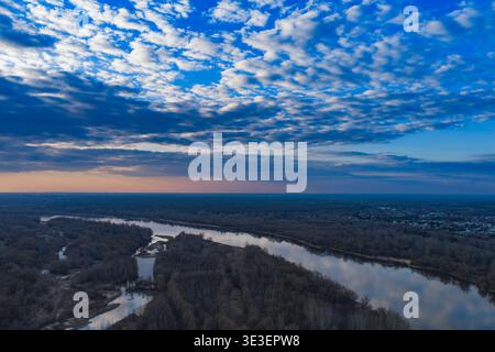Aus der Vogelperspektive auf die Weichsel in der Nähe von Warschau in der Abenddämmerung sehen Sie einen mäandernden Kanal, Wälder, Feuchtgebiete und Sandbänke mit einer kleinen Stadt auf der Plattform Stockfoto