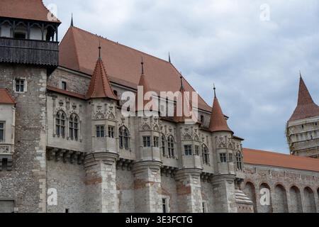 Detailansicht der Corvin Castle Fassade mit Türmen, Bogenfenstern und Steinmauerwerk in Hunedoara, Rumänien. Stockfoto