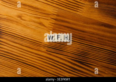 Lviv Ukraine 02.26.26 Scrabble-Fliesen schreiben W, F, H auf einem Holztisch während des Nationalen Scrabble-Tages. Die Leute treffen sich, um Spiele zu genießen und ihre Worte zu teilen Stockfoto