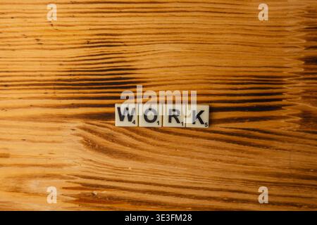 Lemberg Ukraine 02.26.26 die Buchstaben „Arbeit“ werden auf einem Holztisch platziert. Diese Szene markiert den National Scrabble Day und fördert das Wortspiel. Stockfoto