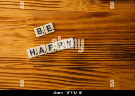 Lemberg Ukraine 02.26.26 Menschen genießen den nationalen Scrabble-Tag, indem sie Wörter auf einem Holztisch kreieren. Die Spieler konzentrieren sich darauf, Wörter zu Formen und gemeinsam Spaß zu haben Stockfoto