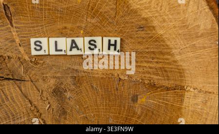 Lviv Ukraine 02.26.26 Spieler genießen den nationalen Scrabble Day, indem sie Buchstabensteine, die den SCHRÄGSTRICH auf einer Holzfläche buchstabieren, arrangieren. Der Fokus liegt auf dem g Stockfoto