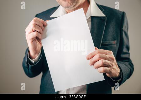 Geschäftsmann im Anzug mit leerem weißem Papierbogen, selektiver Fokus Stockfoto