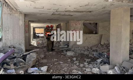 ARAD, ISRAEL - 22. MÄRZ: Mitglieder des Front-Home-Kommandos untersuchen die Schäden in einem Wohngebäude, das am 22. März 2026 von einer iranischen ballistischen Rakete in Arad, Israel, getroffen wurde. Der Iran feuerte weiterhin Drohnen und Raketen auf Israel ab, nachdem die Vereinigten Staaten und Israel Anfang des 28. Februar einen gemeinsamen Angriff auf den Iran gestartet hatten. Stockfoto