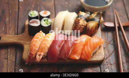 Verschiedene Sushi-Sets mit Nigiri- und Maki-Rollen auf einem Holzbrett Stockfoto